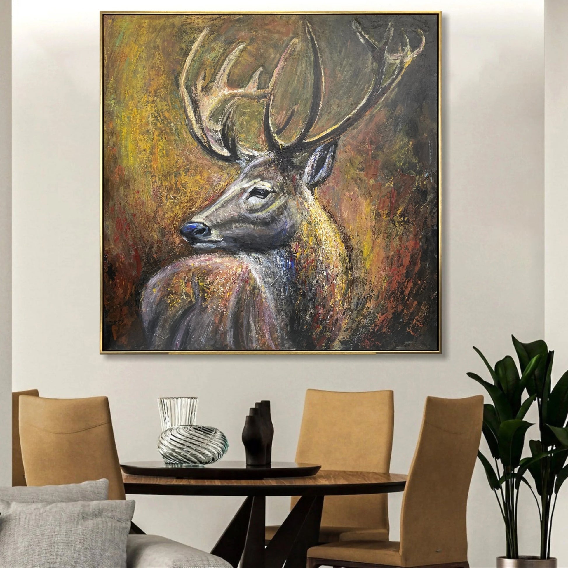 a large painting of a deer with antlers hanging on a wall above a wooden dining table with four chairs.