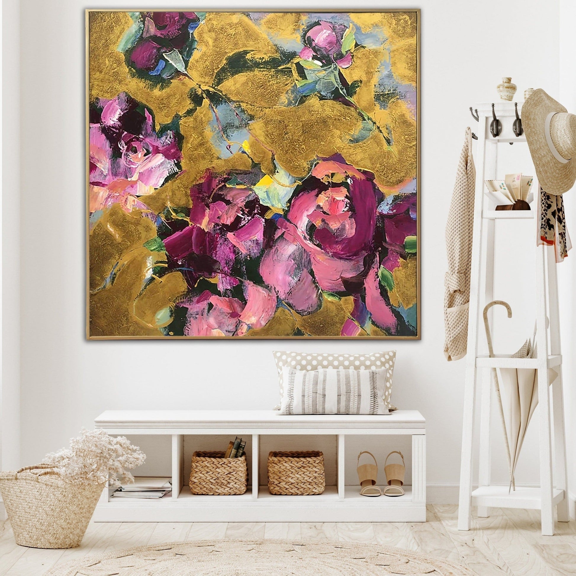a large, colorful painting of flowers hanging on a wall in a room with a white bench, a shelf with baskets, and a hat rack.