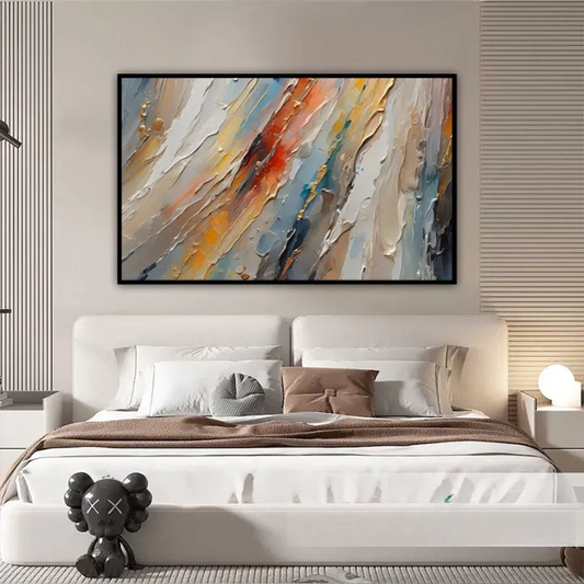 a large, abstract painting hanging on a wall above a bed with white headboard and pillows.