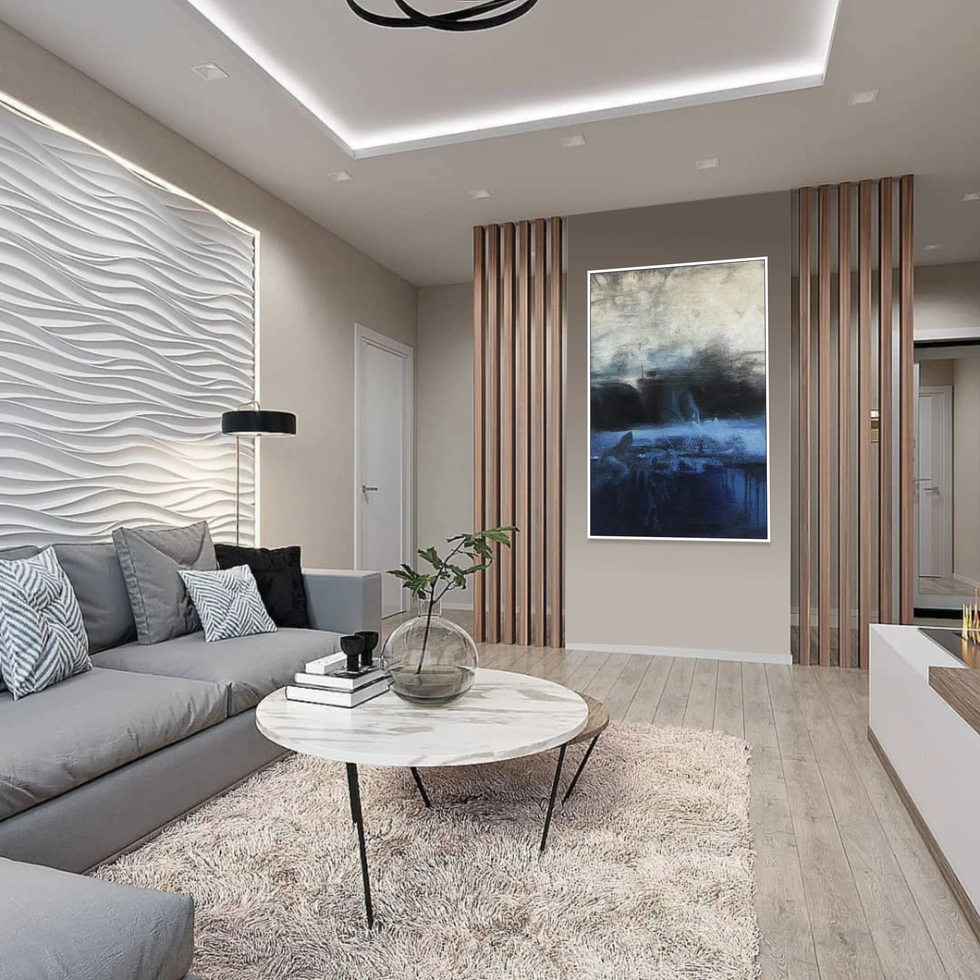 a modern living room with a gray sofa, a round coffee table, and a large abstract painting on the wall.