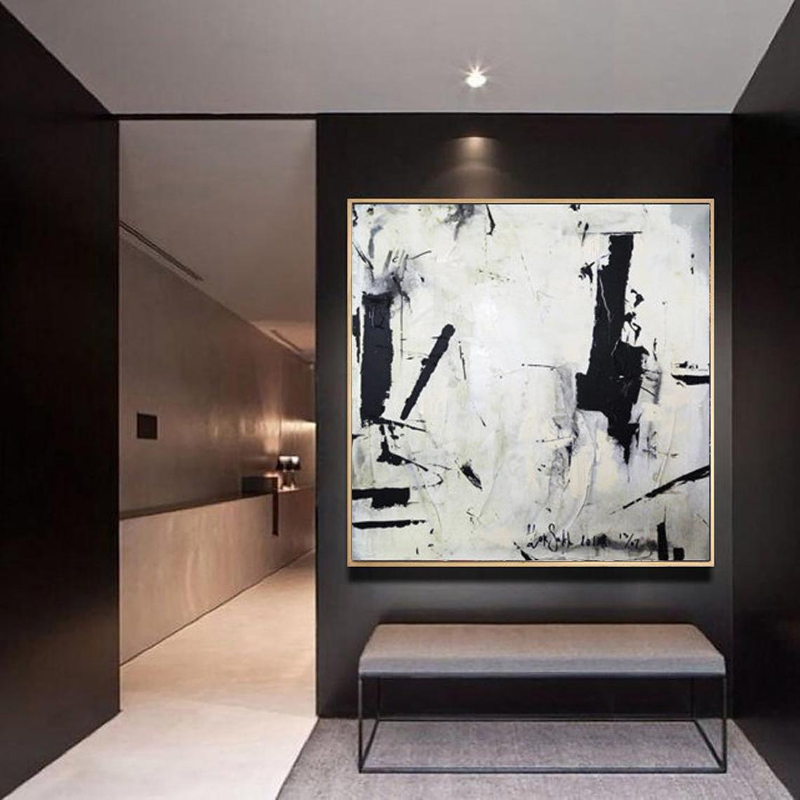 a black and white painting hanging on a wall