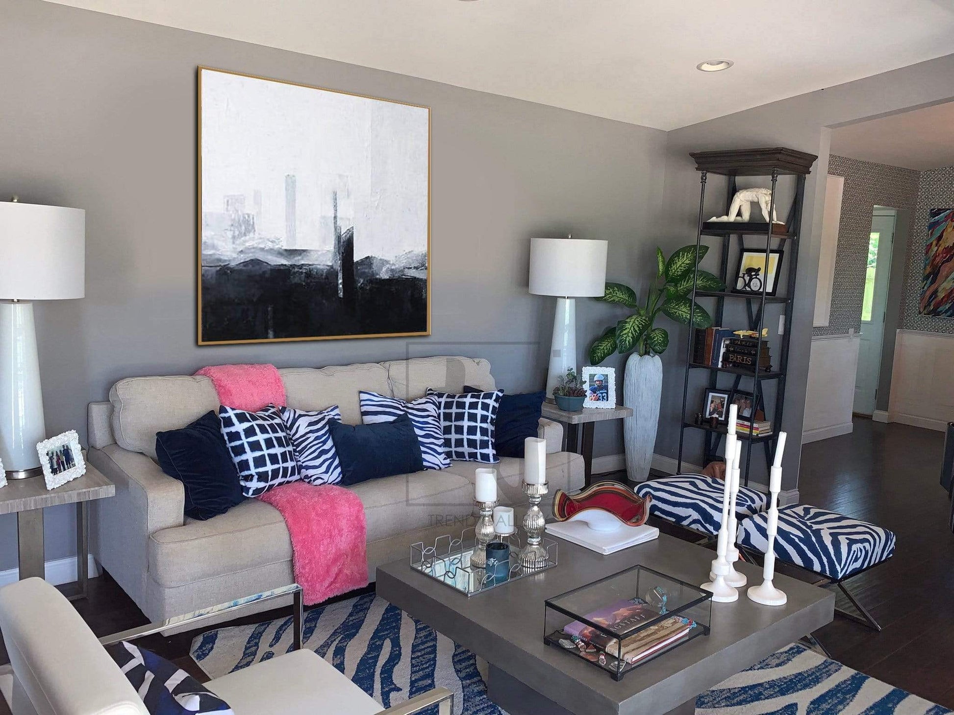 a living room filled with furniture and a painting on the wall