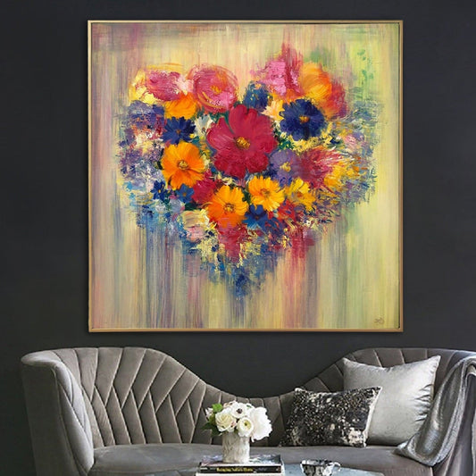 a large, vibrant painting of a heart-shaped arrangement of colorful flowers, hanging on a wall above a gray sofa with decorative pillows.