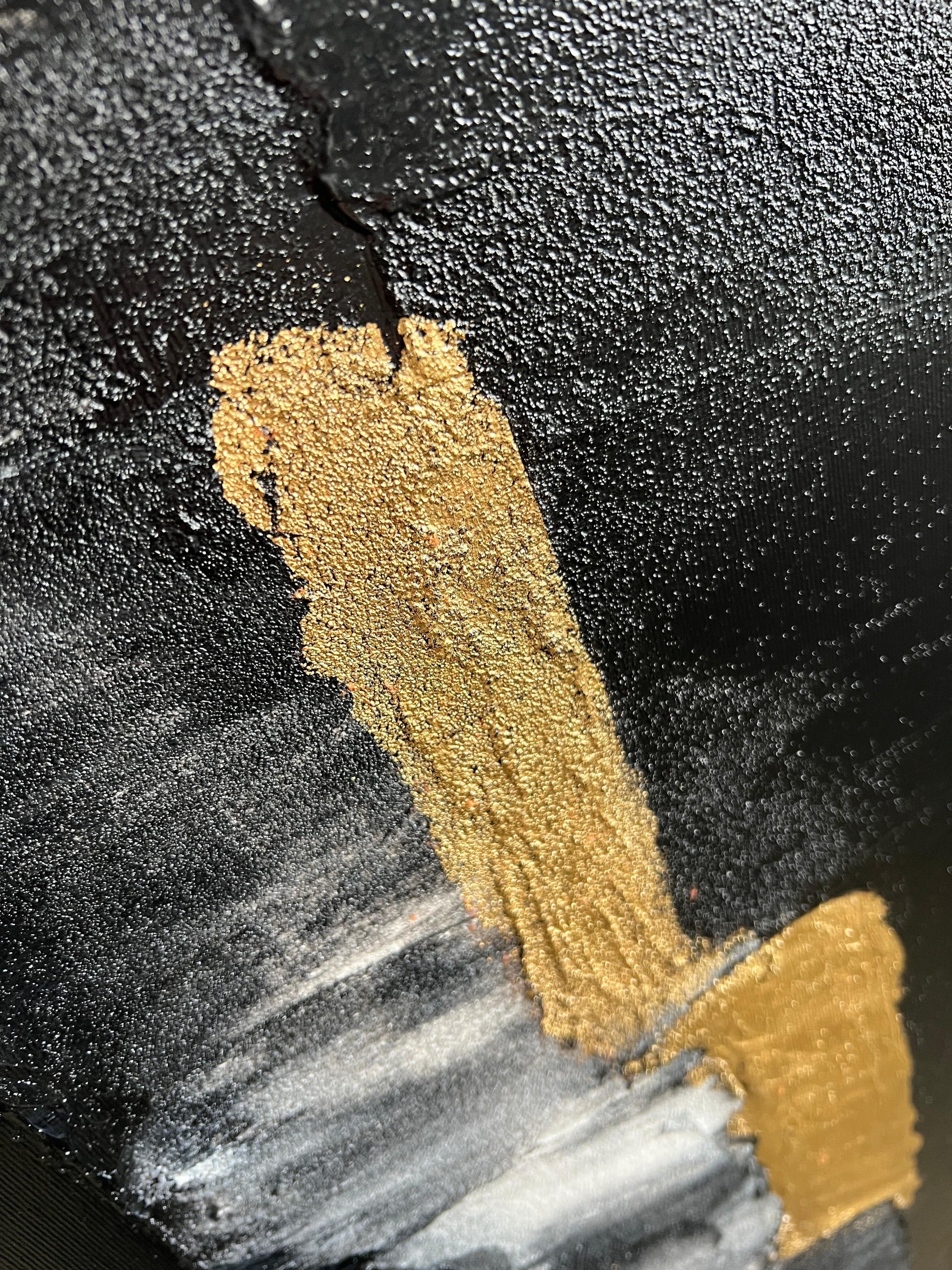 a close up of a black and gold painted object