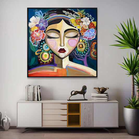 a large, colorful painting of a woman's face with a flower crown on her head, hanging on a wall above a white cabinet with drawers.