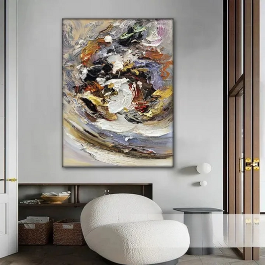 a large abstract painting hanging on a wall in a modern living room. The painting has a vibrant mix of colors and shapes, creating a dynamic and visually striking composition. The room is furnished with a white armchair, a glass coffee table, and a wooden sideboard, contributing to the overall contemporary aesthetic.