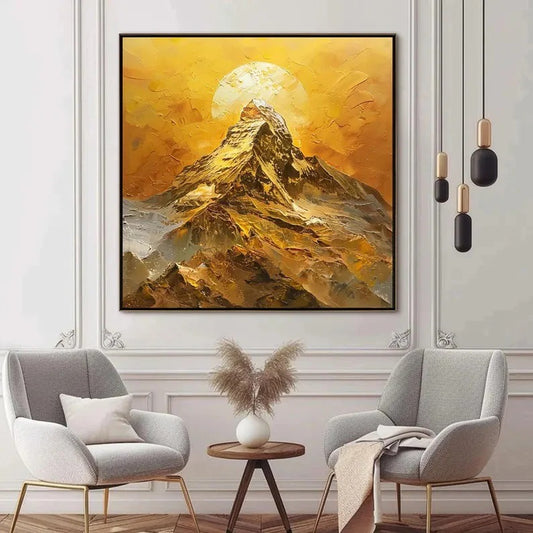 a large painting of a mountain landscape with a sun in the background, hanging on a wall above a seating area with two gray armchairs and a small wooden table.