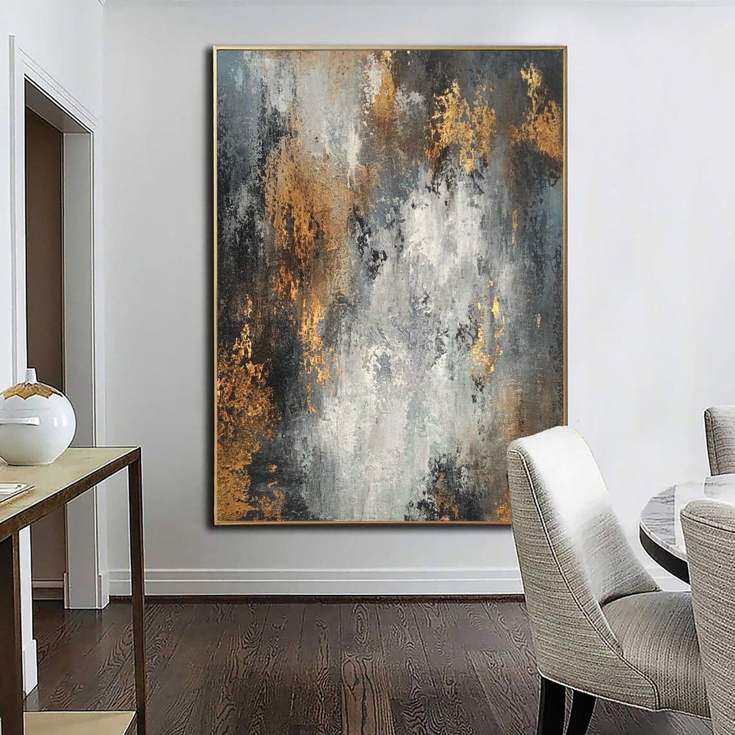 a large abstract painting hanging on a white wall in a room with a wooden floor.