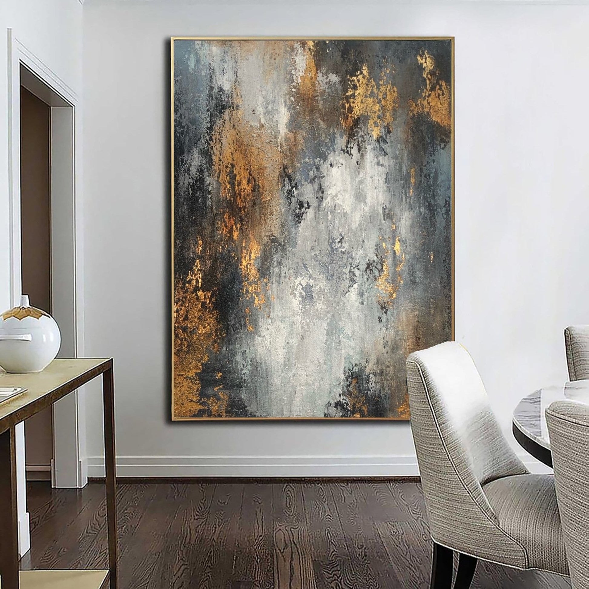 a large abstract painting hanging on a white wall in a room with a wooden floor.