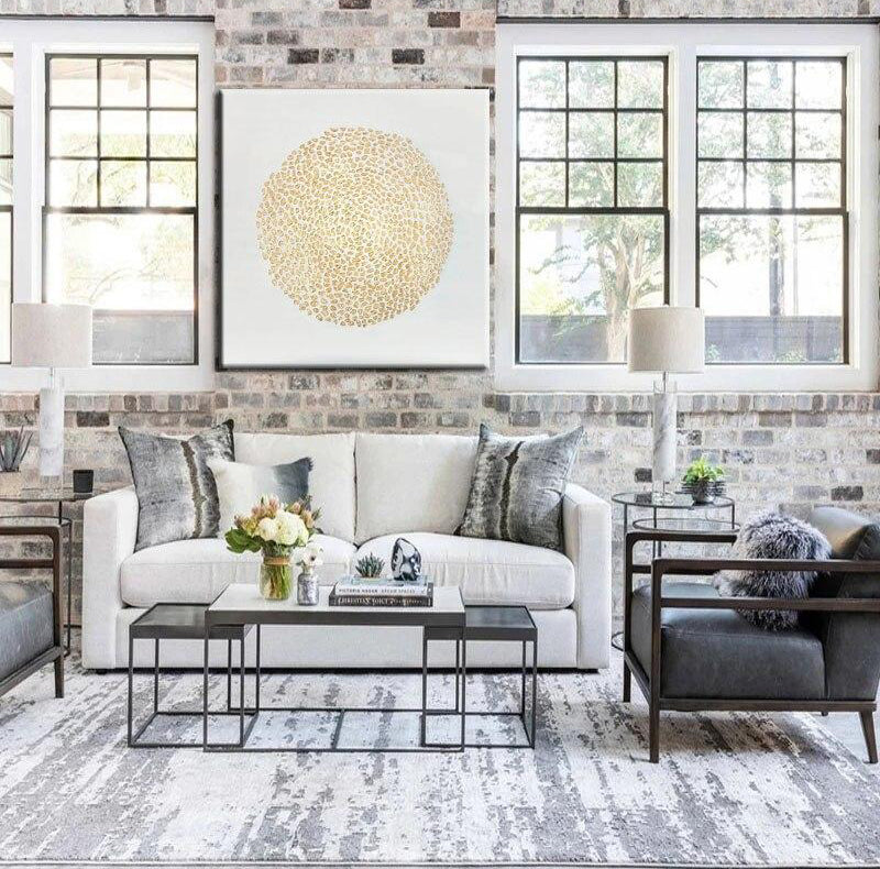 a living room filled with furniture and a brick wall