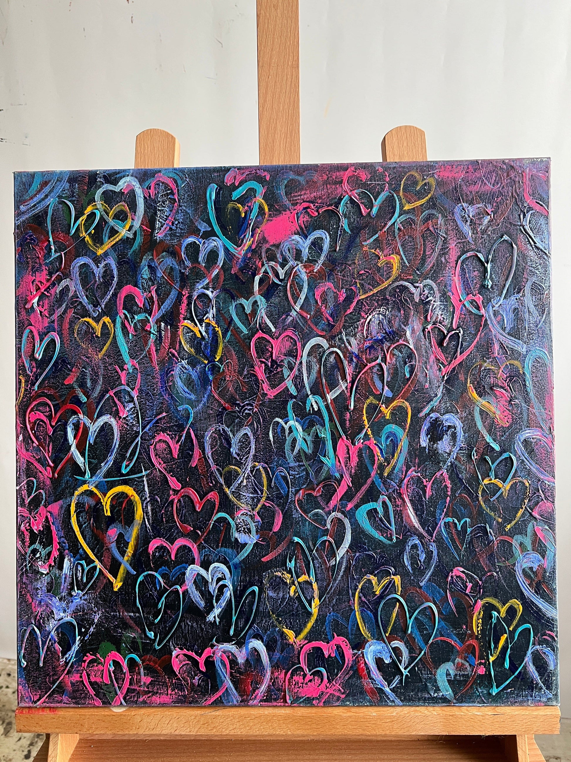 an easel with a painting of hearts painted on it