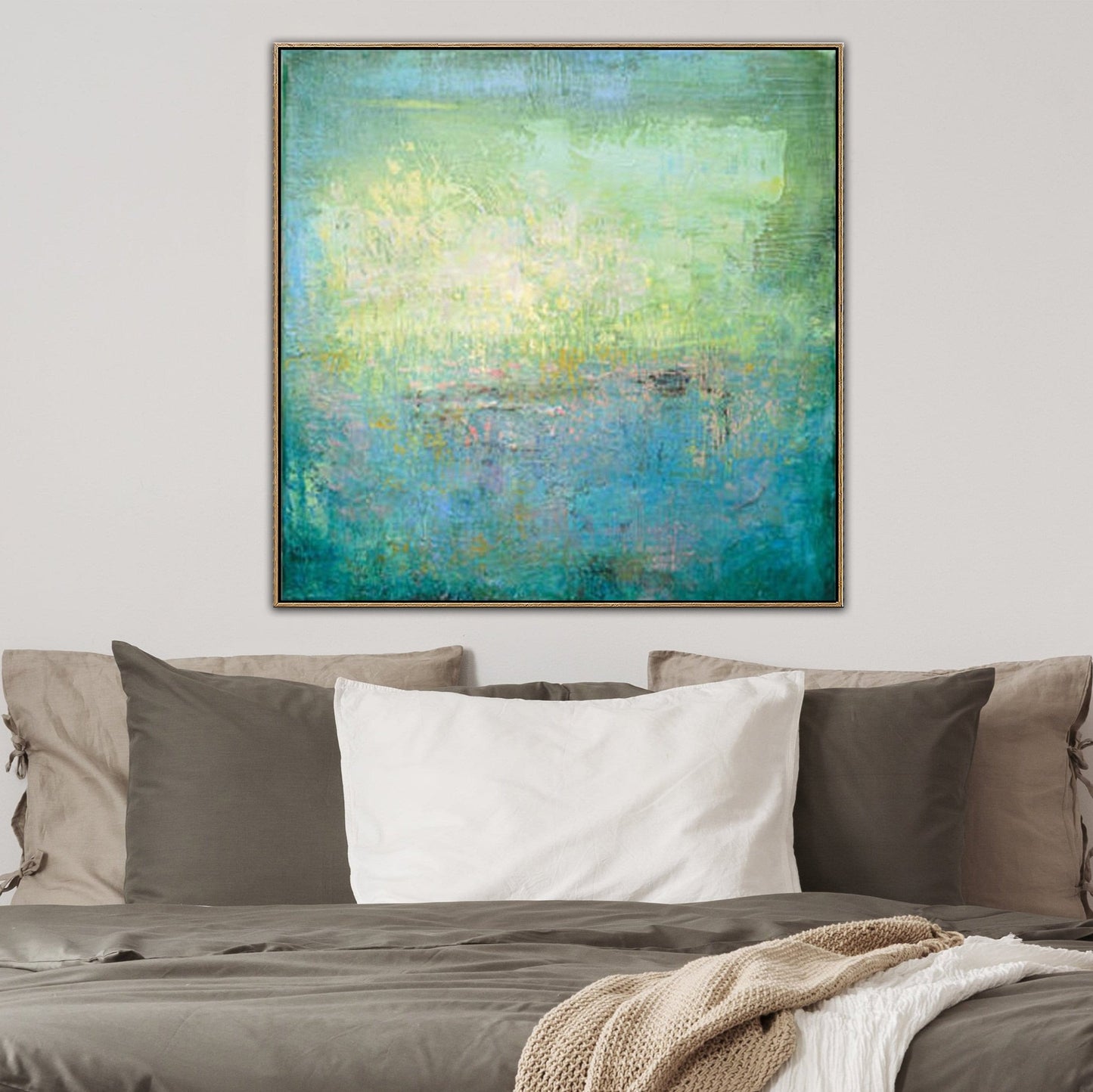 a large abstract painting hanging on a wall above a bed with a gray comforter and white pillows.