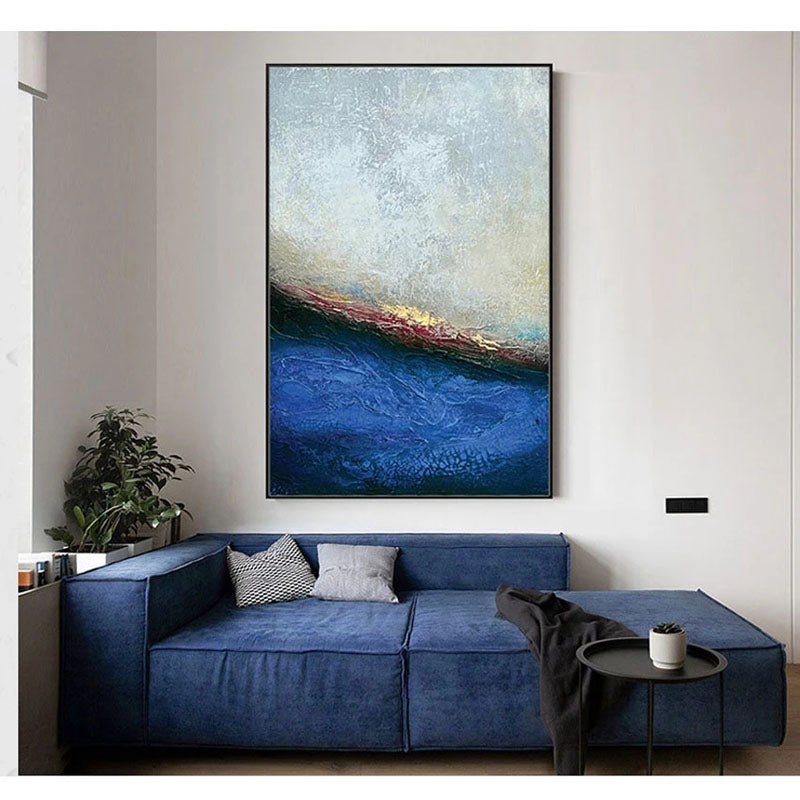 a living room with a blue couch and a painting on the wall