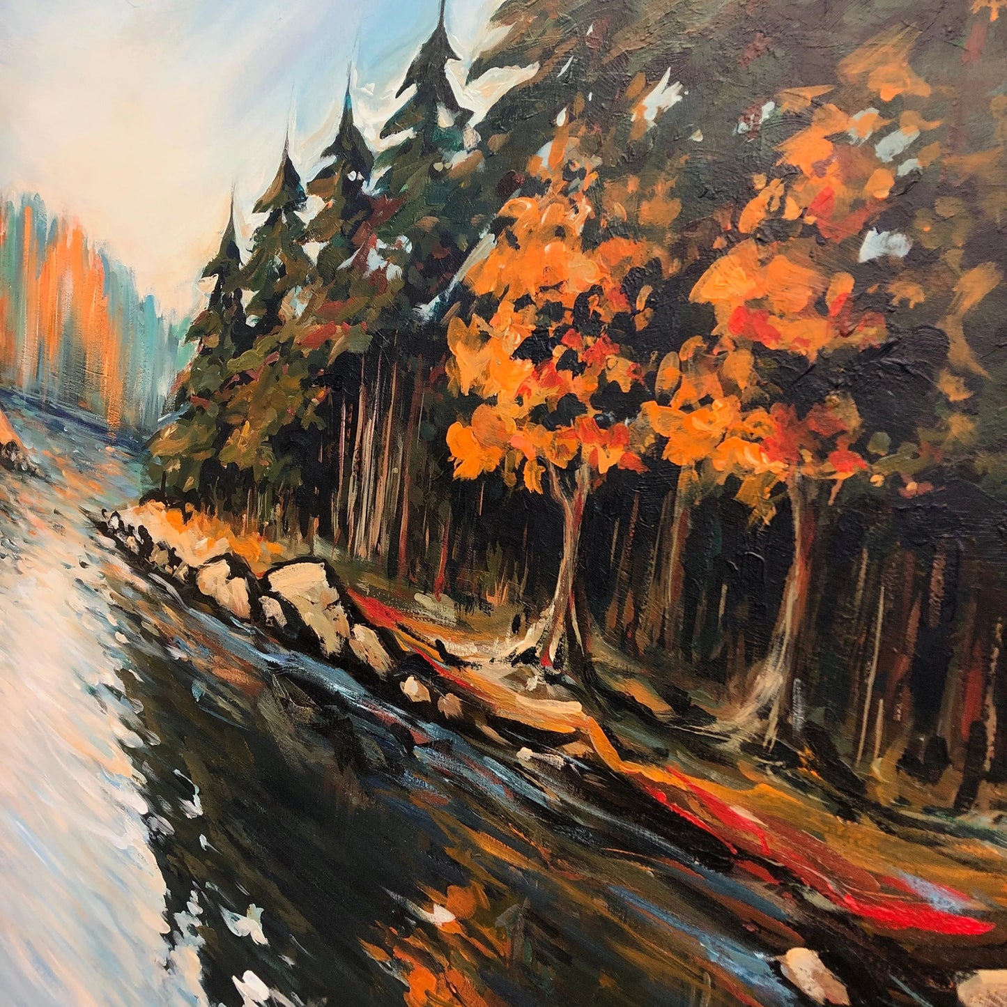The image is an oil painting depicting a serene landscape with a river, trees, and a rocky shore. The painting features a mix of warm and cool colors, creating a vibrant and dynamic scene.