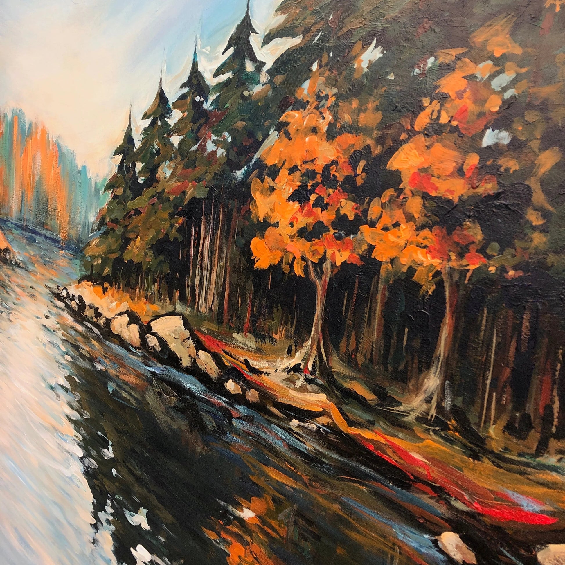 The image is an oil painting depicting a serene landscape with a river, trees, and a rocky shore. The painting features a mix of warm and cool colors, creating a vibrant and dynamic scene.