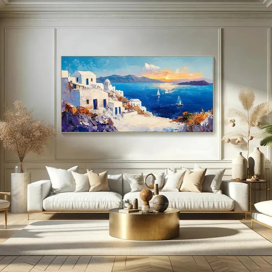 a large painting of a coastal town with white buildings, blue sky, and boats on the water, hanging on a wall above a white sofa in a living room.