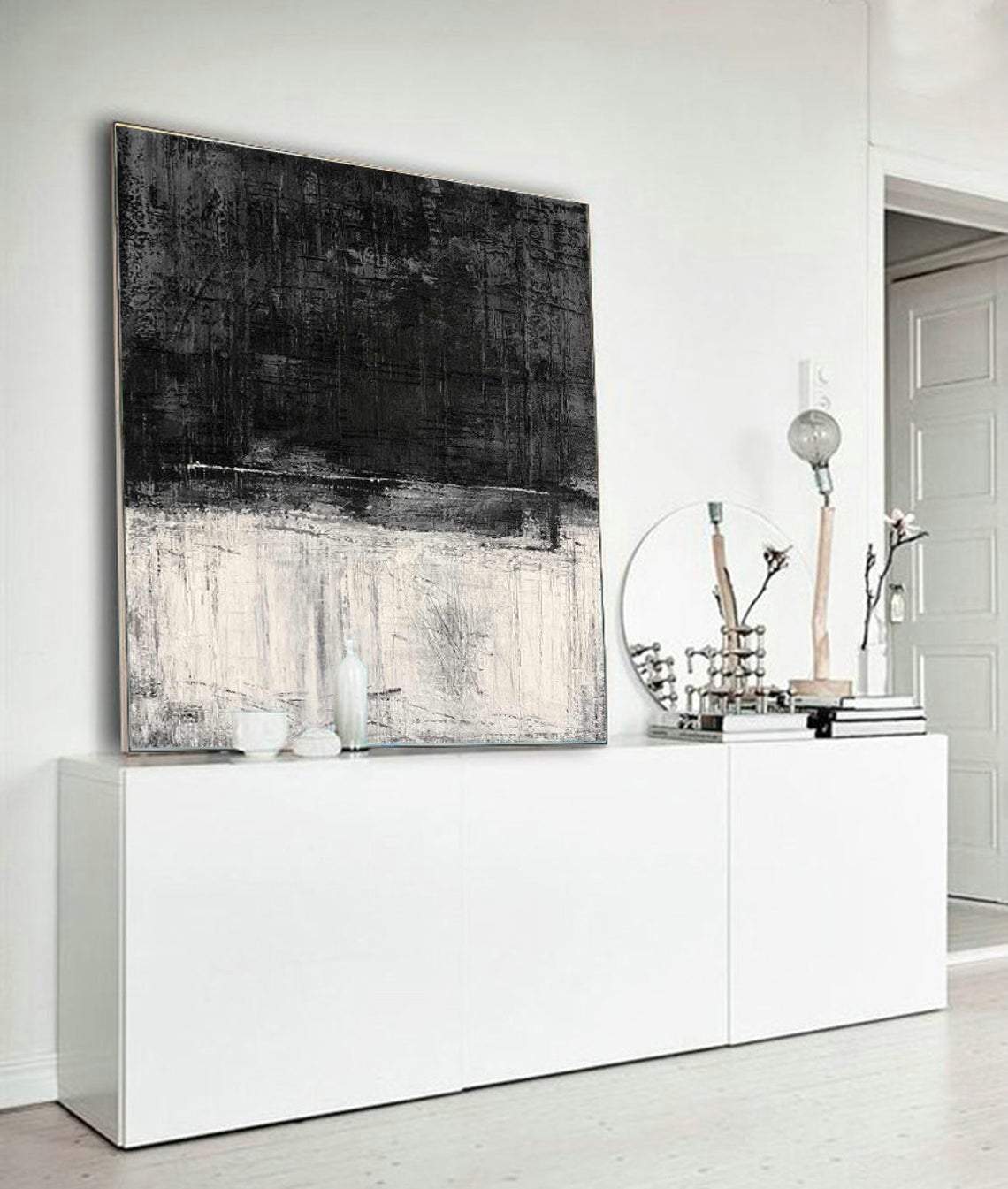 a large black and white painting hanging on a wall