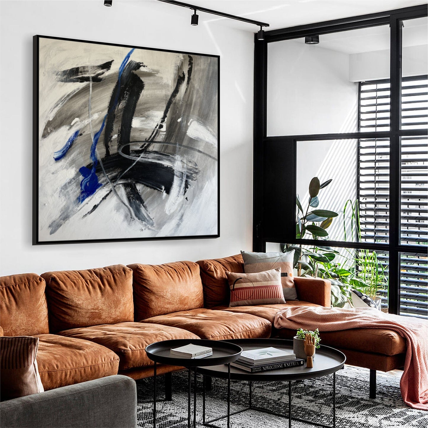 a living room filled with furniture and a painting on the wall