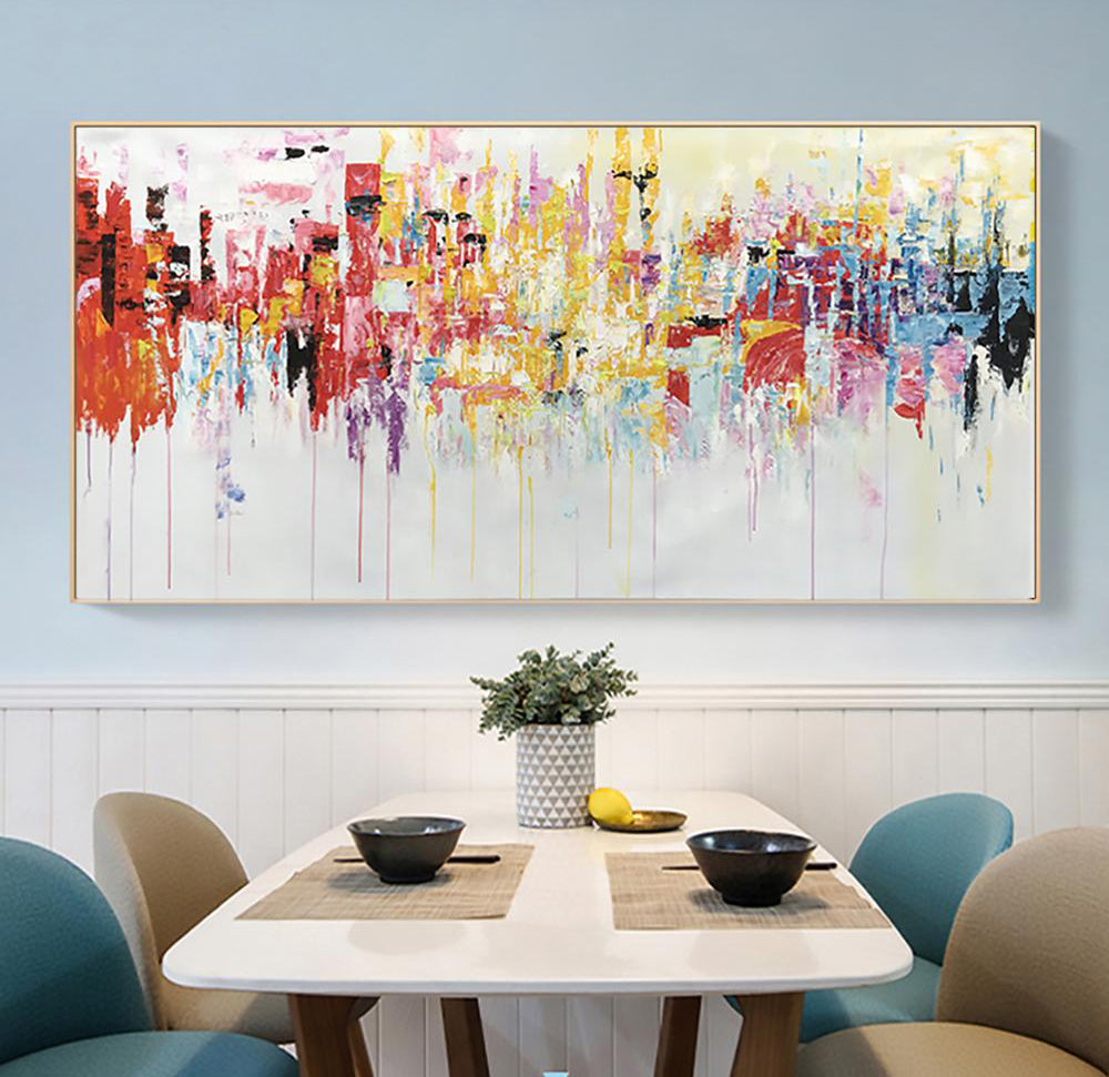 a painting hanging on a wall above a dining room table