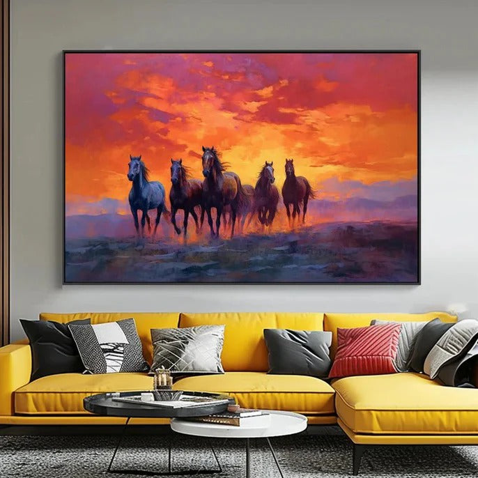 a group of horses running across a field at sunset, with a vibrant sky in the background.