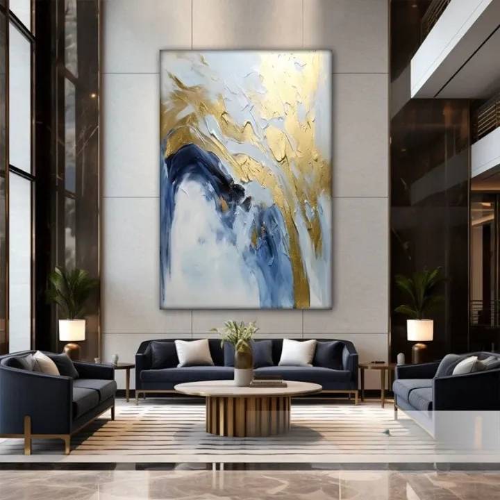 a luxurious living room with a large abstract painting on the wall, featuring blue and gold colors. The room is furnished with two blue sofas and a round wooden coffee table, creating a modern and sophisticated atmosphere.