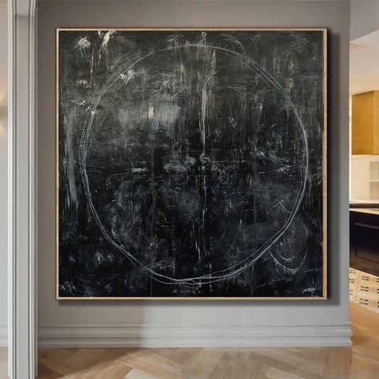 a large, abstract black and white painting of a circle on a wall.