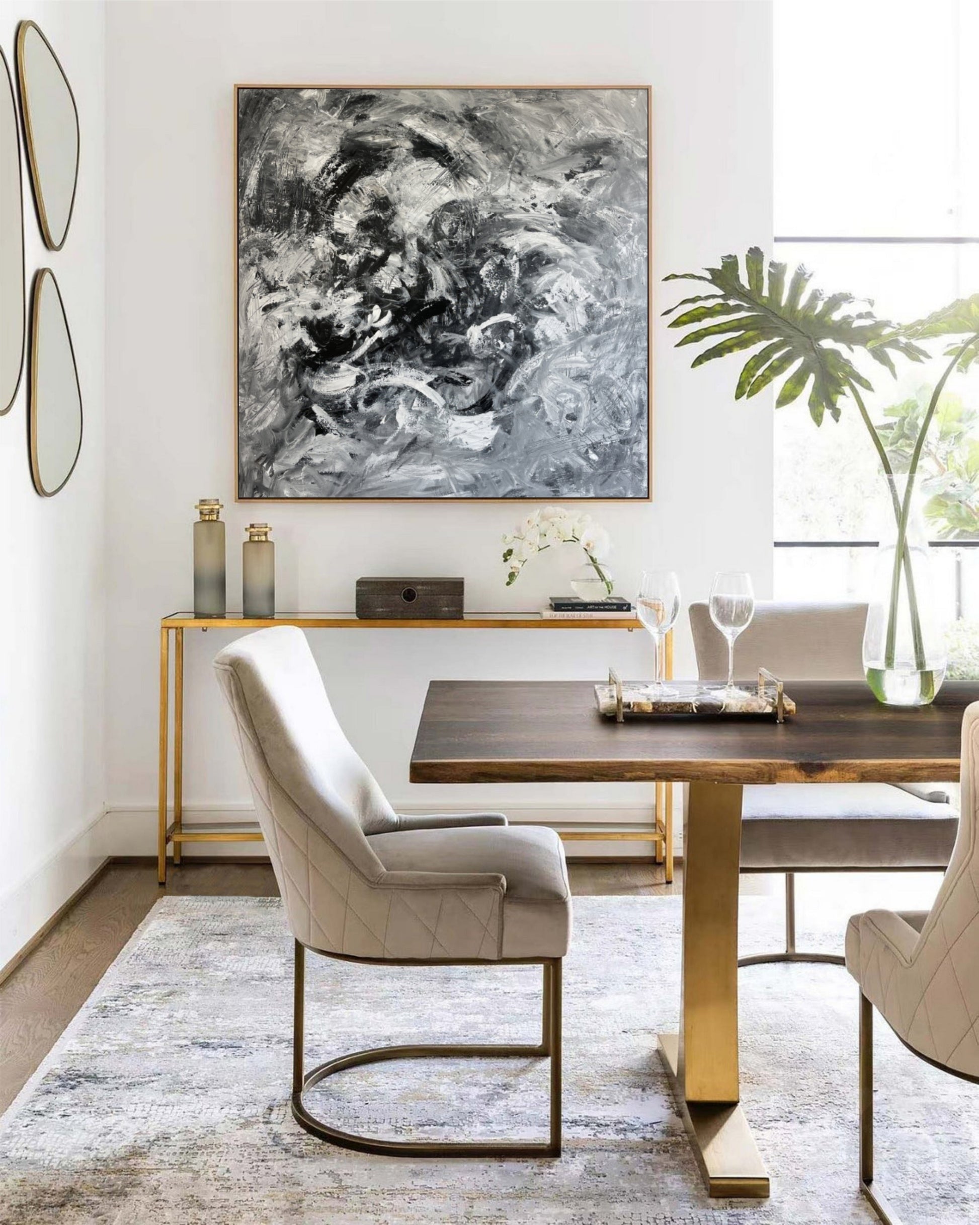 a dining room table with chairs and a painting on the wall