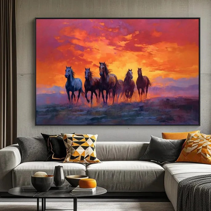 a large painting of five horses running across a field at sunset, with a vibrant orange and pink sky in the background.