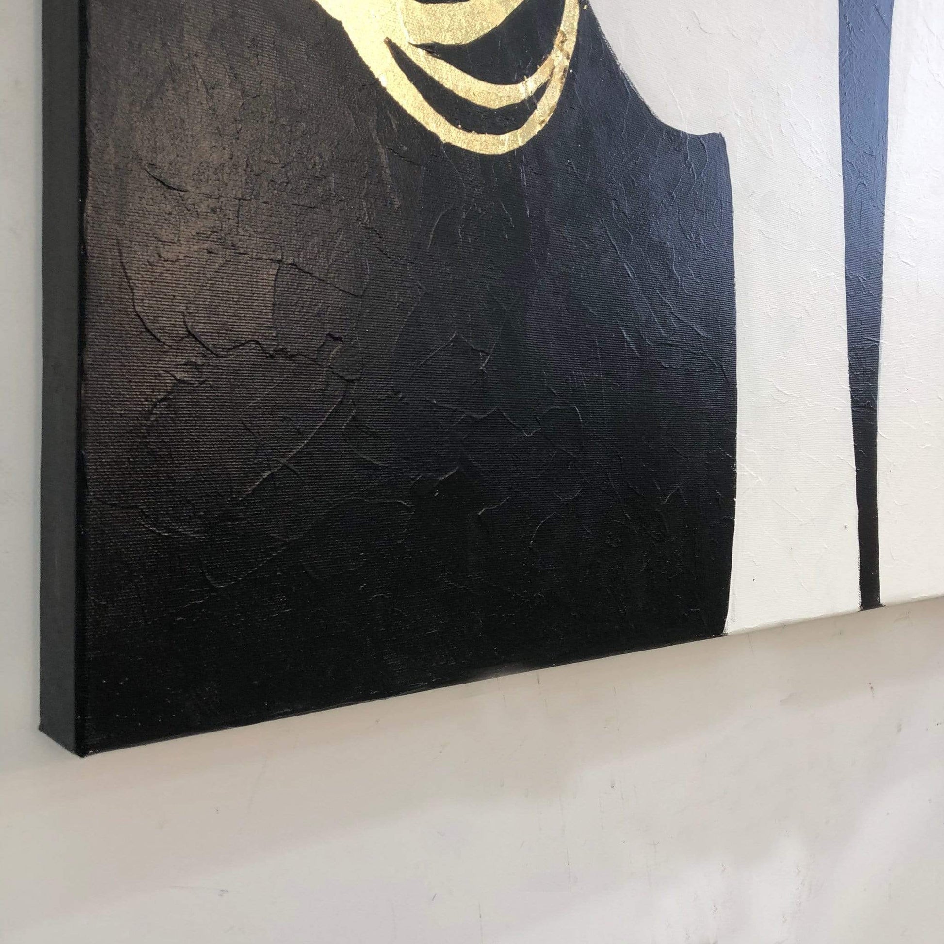 a black and gold painting on a white wall