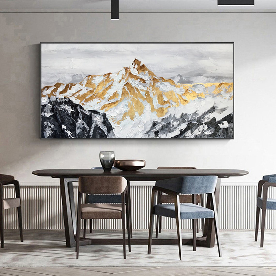 a dining room table with chairs and a painting on the wall