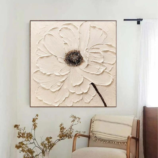 a large, white, flower-like painting hanging on a wall, with a wooden chair and a vase of dried flowers in the foreground.