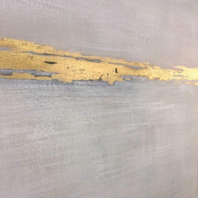 The image is a close-up of a textured surface with a horizontal line of gold leaf or gold foil. The line appears to be slightly worn, suggesting it has been in place for some time. The overall color scheme is a combination of gray and gold, creating a visually striking contrast.