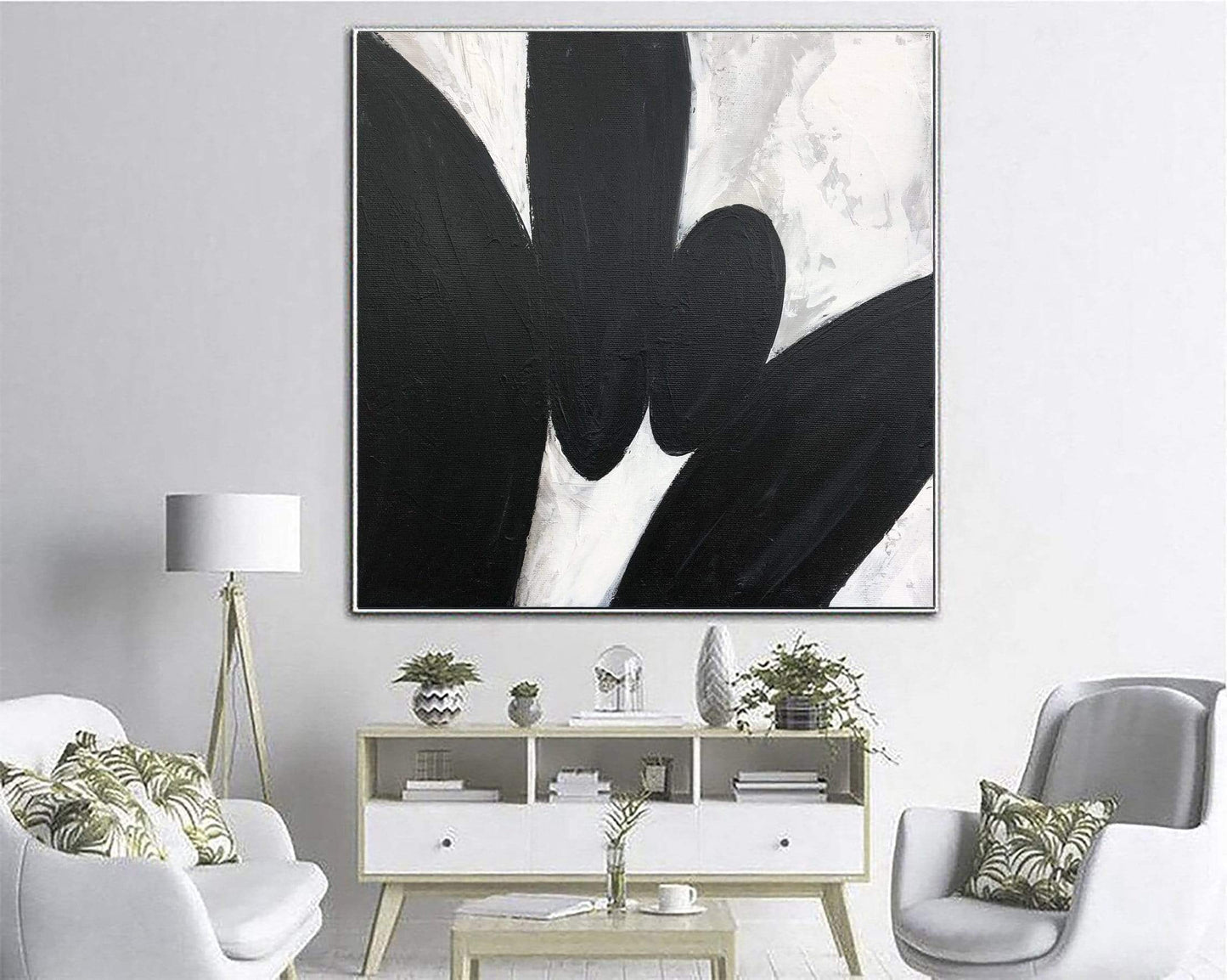 a living room with white furniture and a black and white painting