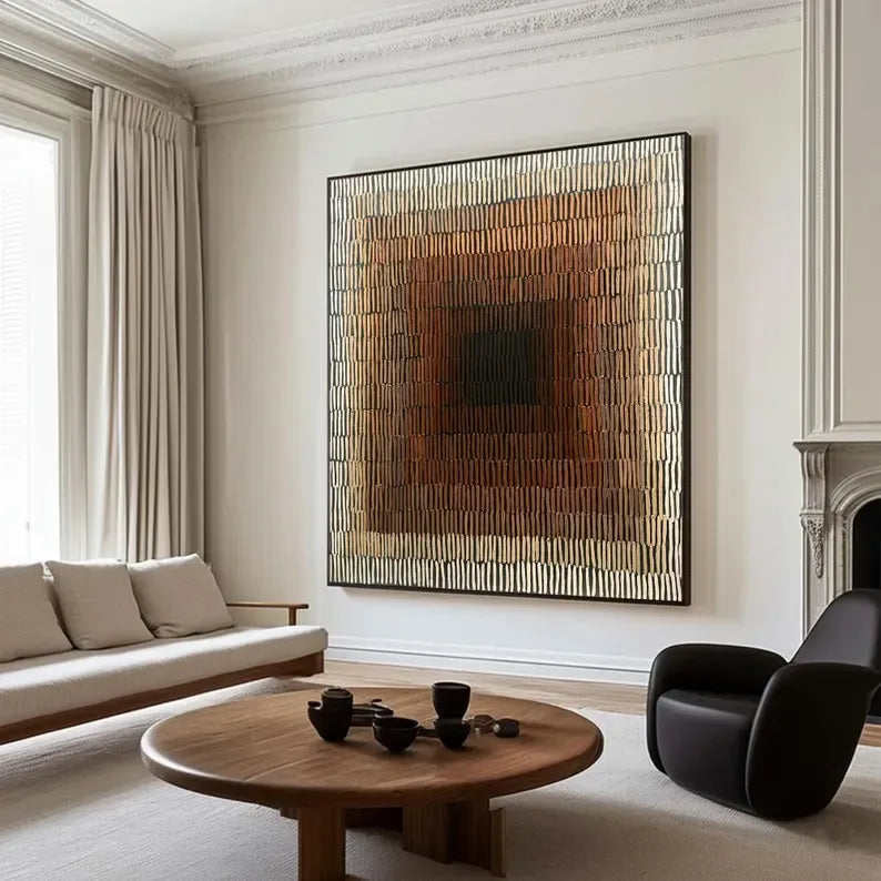 a modern living room with a large abstract painting on the wall, a round wooden coffee table with black cups, a white sofa, and a black armchair.