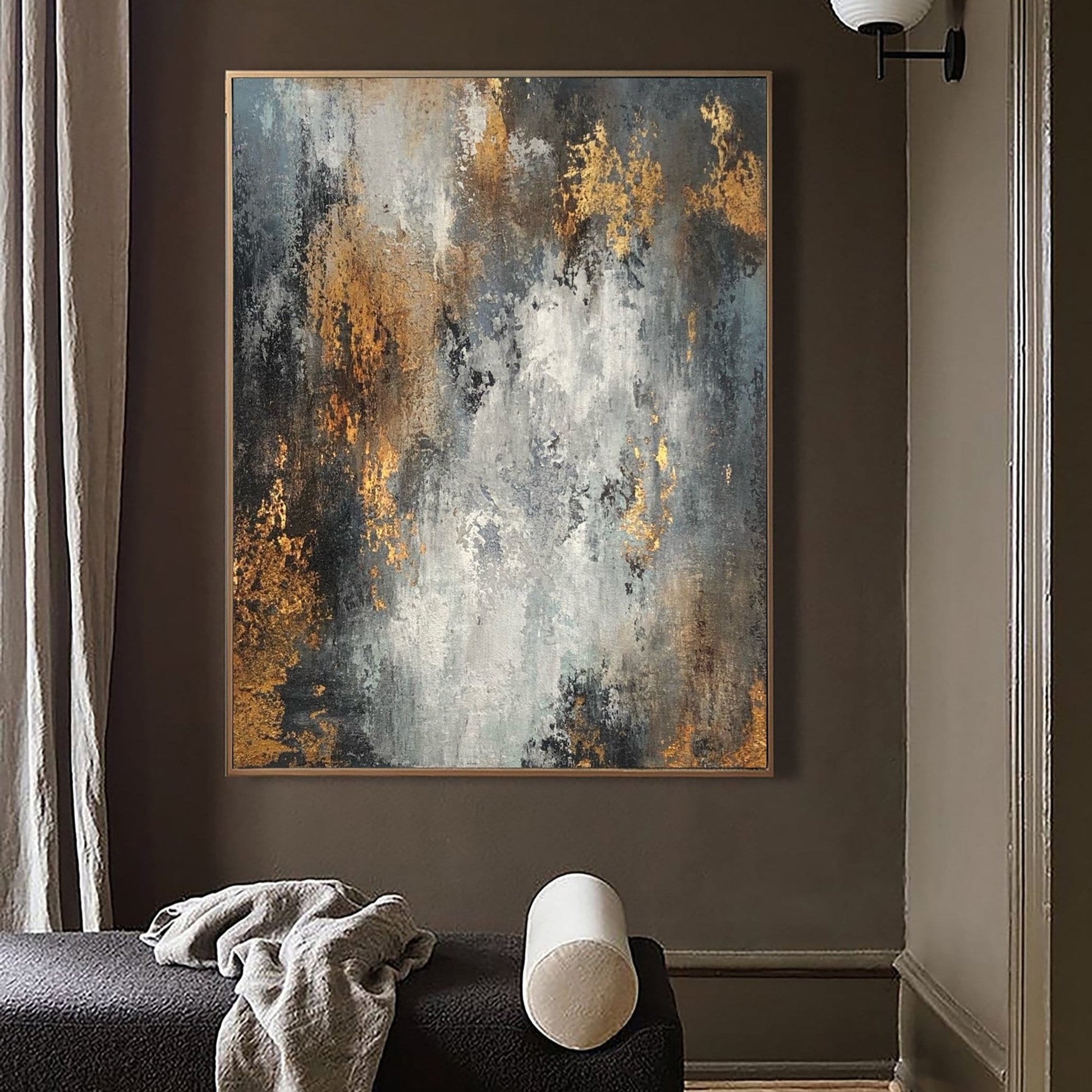 a large abstract painting hanging on a wall, with a black couch and a white pillow in the foreground.