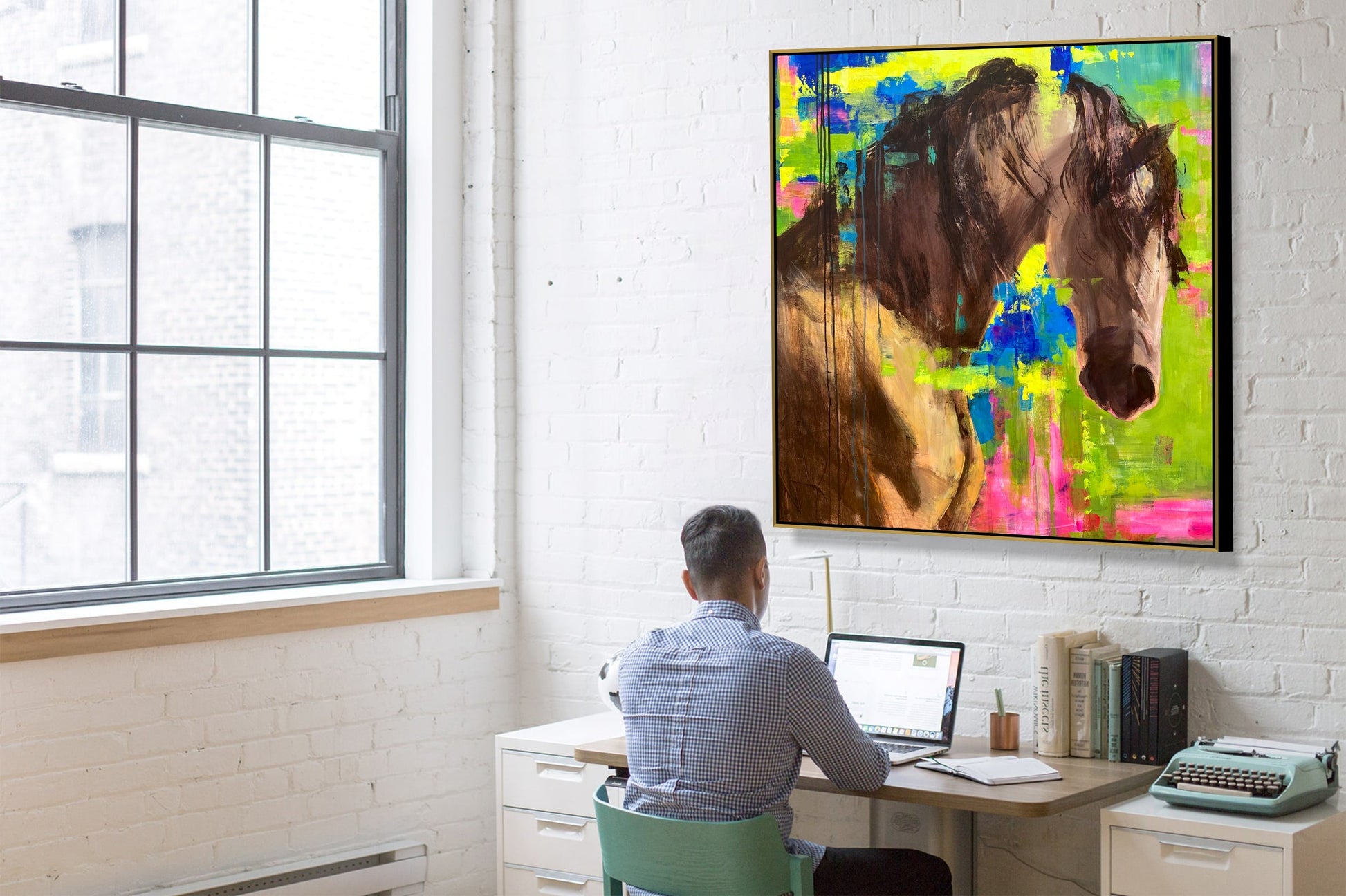 a man sitting at a desk in front of a painting