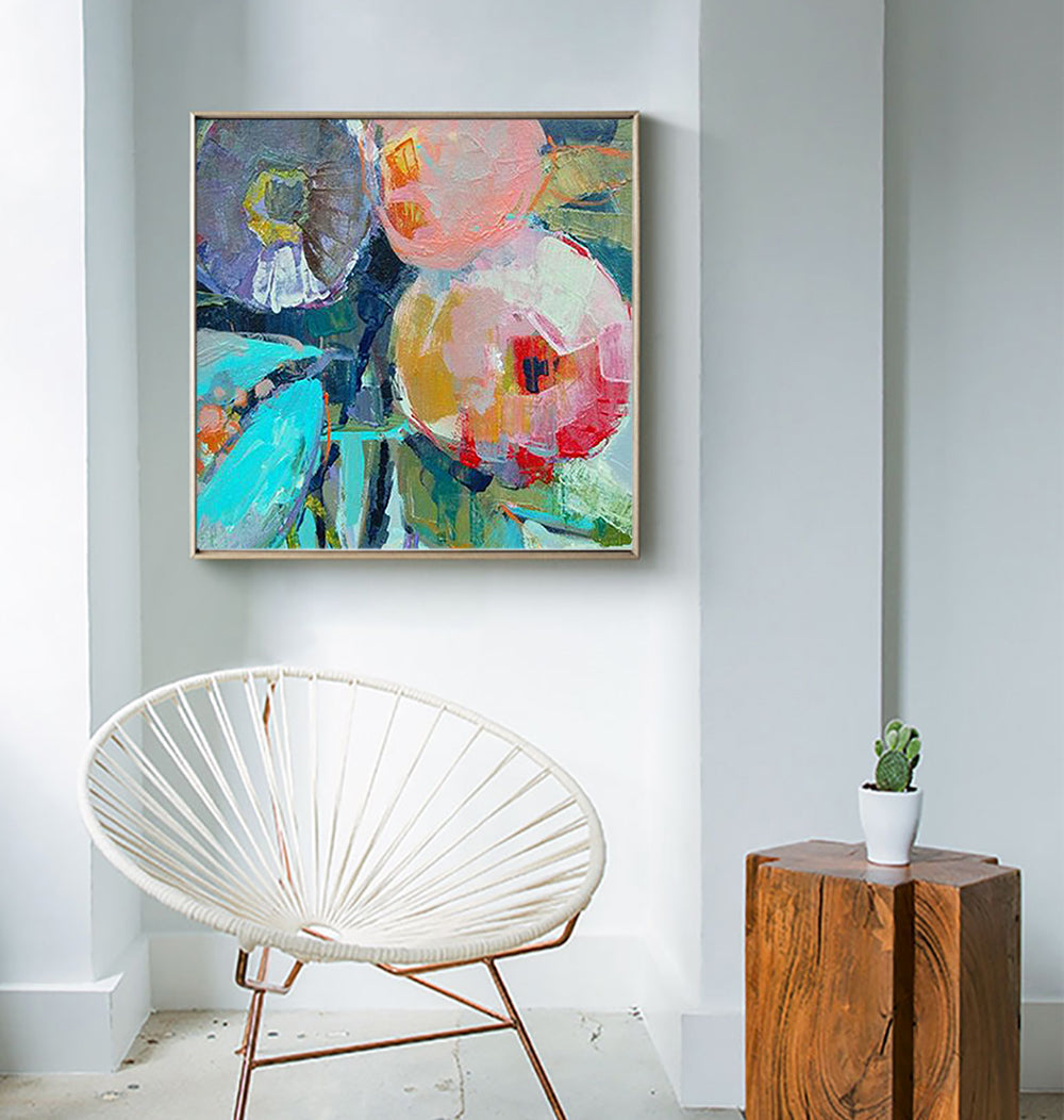 a painting hanging on a wall above a white chair