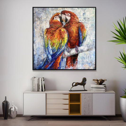 a large painting of two vibrant parrots perched together on a branch, hanging on a wall above a white cabinet with drawers.