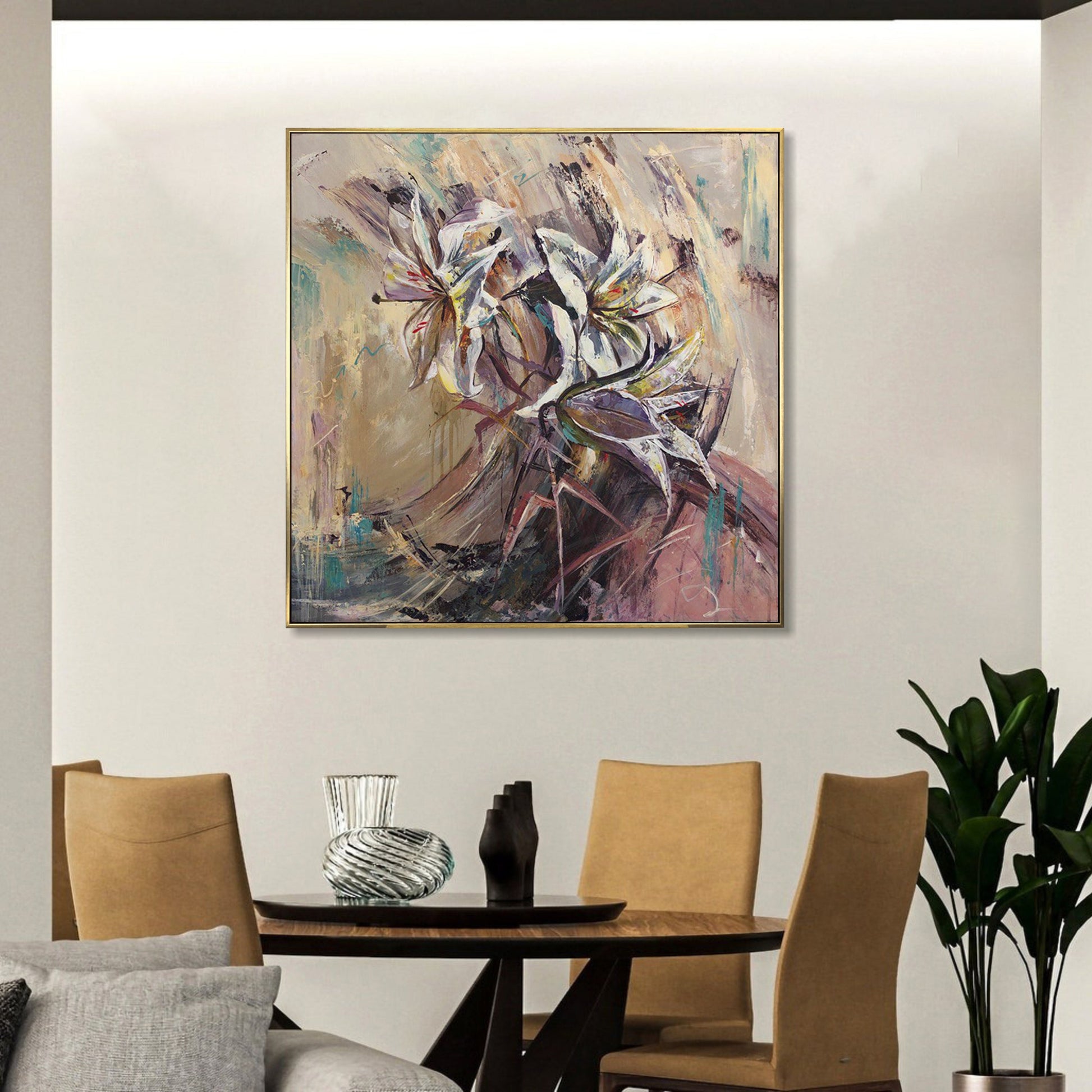 a large abstract painting hanging on a wall above a wooden dining table with four chairs. The painting is colorful and vibrant, with a mix of pink, blue, and green hues. The dining table is set with a vase, a bowl, and a cup, creating a cozy and inviting atmosphere.