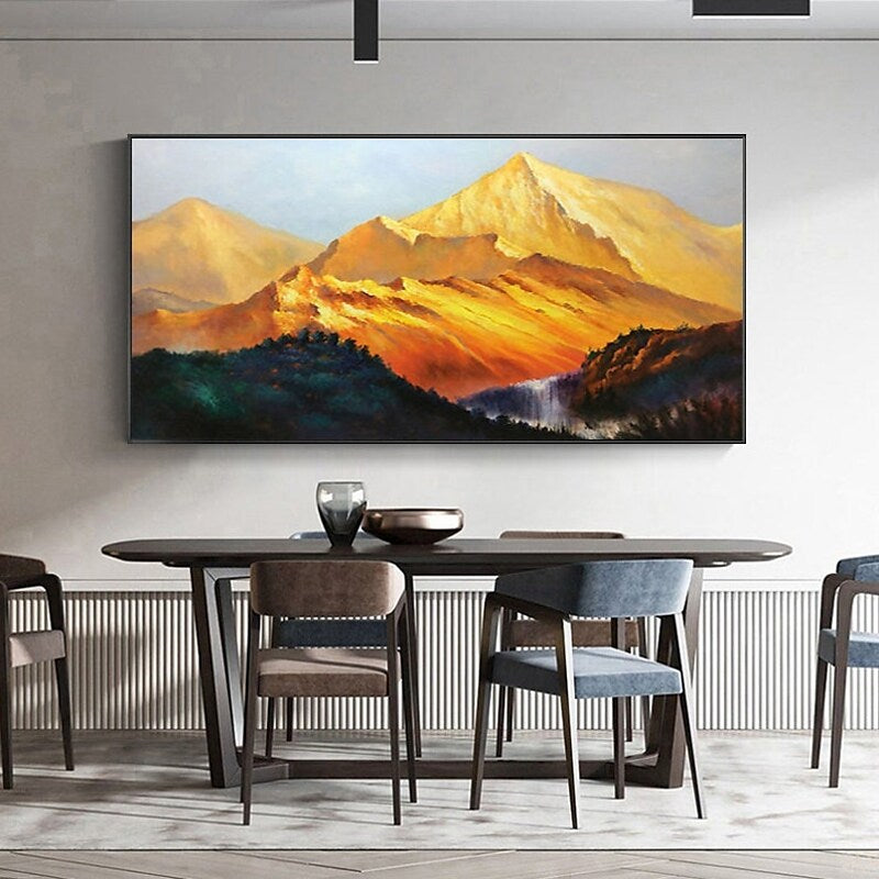 a painting of a mountain range hangs above a dining room table