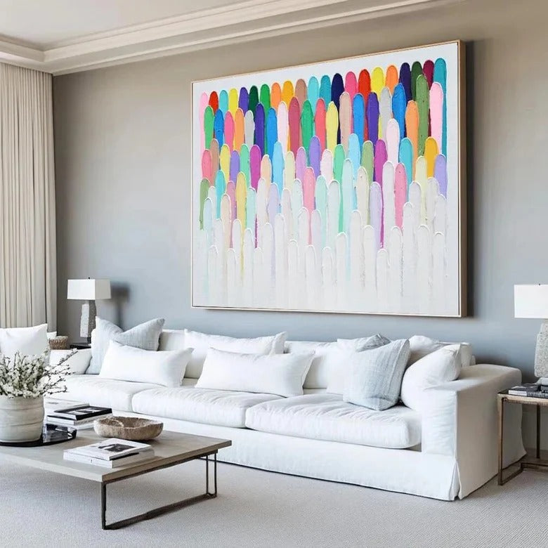 a large, colorful abstract painting hanging on a wall above a white sofa in a modern living room setting.