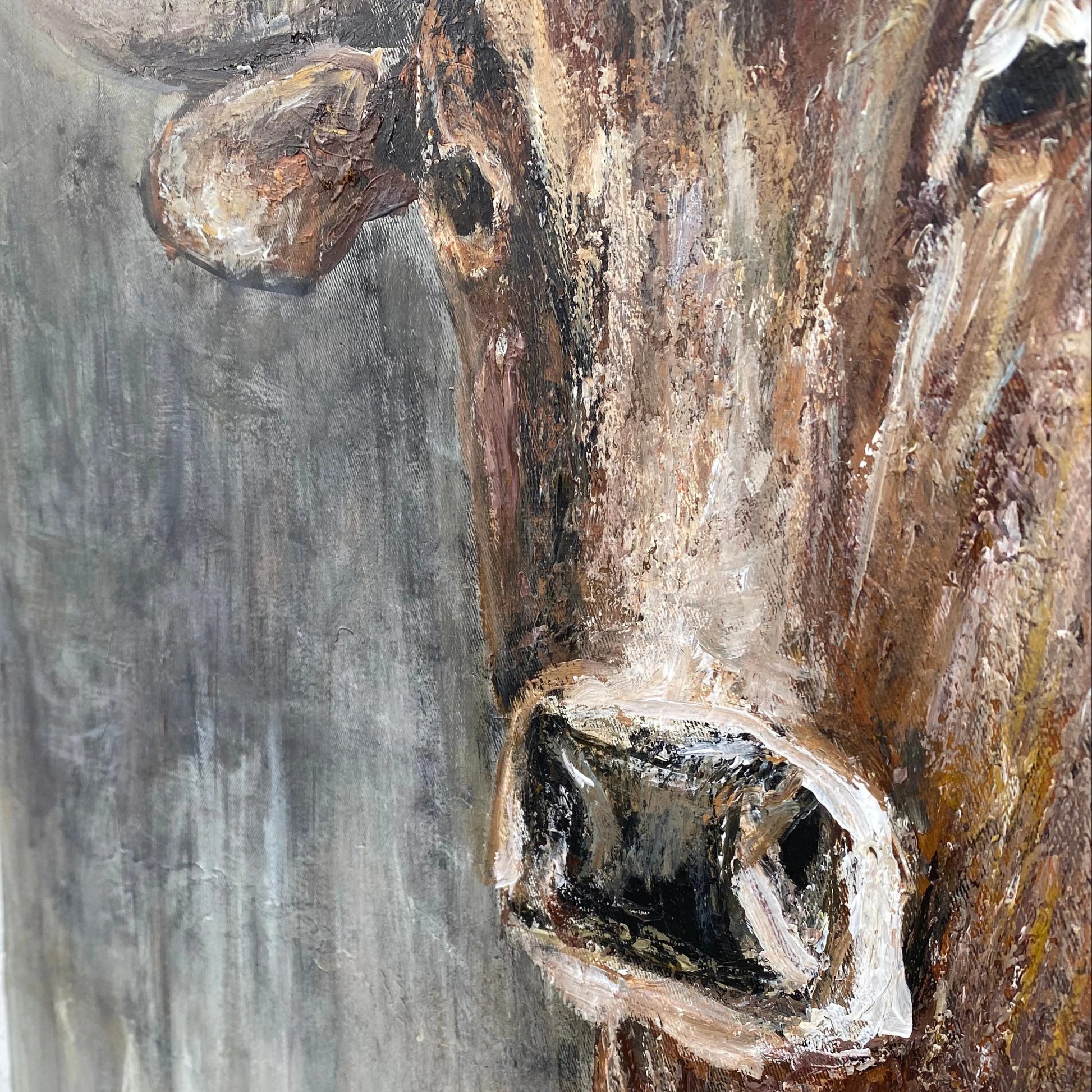 The image is a close-up of a painting depicting a large, detailed brown bull's head.