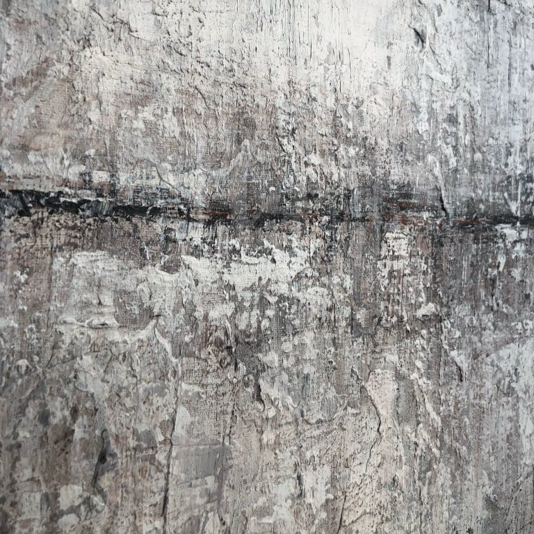 a close-up view of a textured surface, possibly a wall or a piece of furniture, with a rough, uneven appearance. The surface appears to be made of a material that has a gray or white color scheme, with some areas showing signs of wear or damage. The image does not contain any discernible text or specific actions, and it does not depict any objects or scenes. The overall composition of the image is simple and minimalistic, focusing on the texture and surface quality of the material.