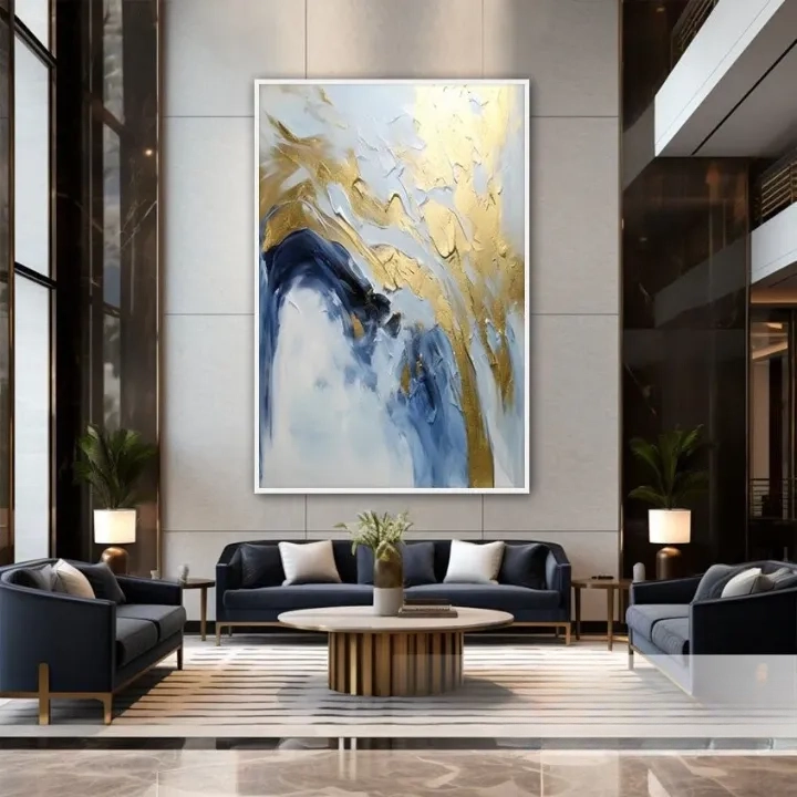 a luxurious living room with a large abstract painting featuring blue and gold colors as the focal point. The room is furnished with two blue sofas and a wooden coffee table, creating a modern and sophisticated atmosphere.