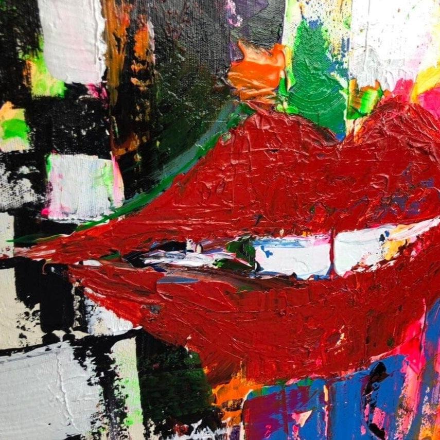 The image is a vibrant, abstract painting featuring bold, expressive brushstrokes in a variety of colors, including red, green, blue, and yellow. The painting appears to be a dynamic and energetic representation of a subject, possibly a person's face or lips, with a sense of movement and energy.
