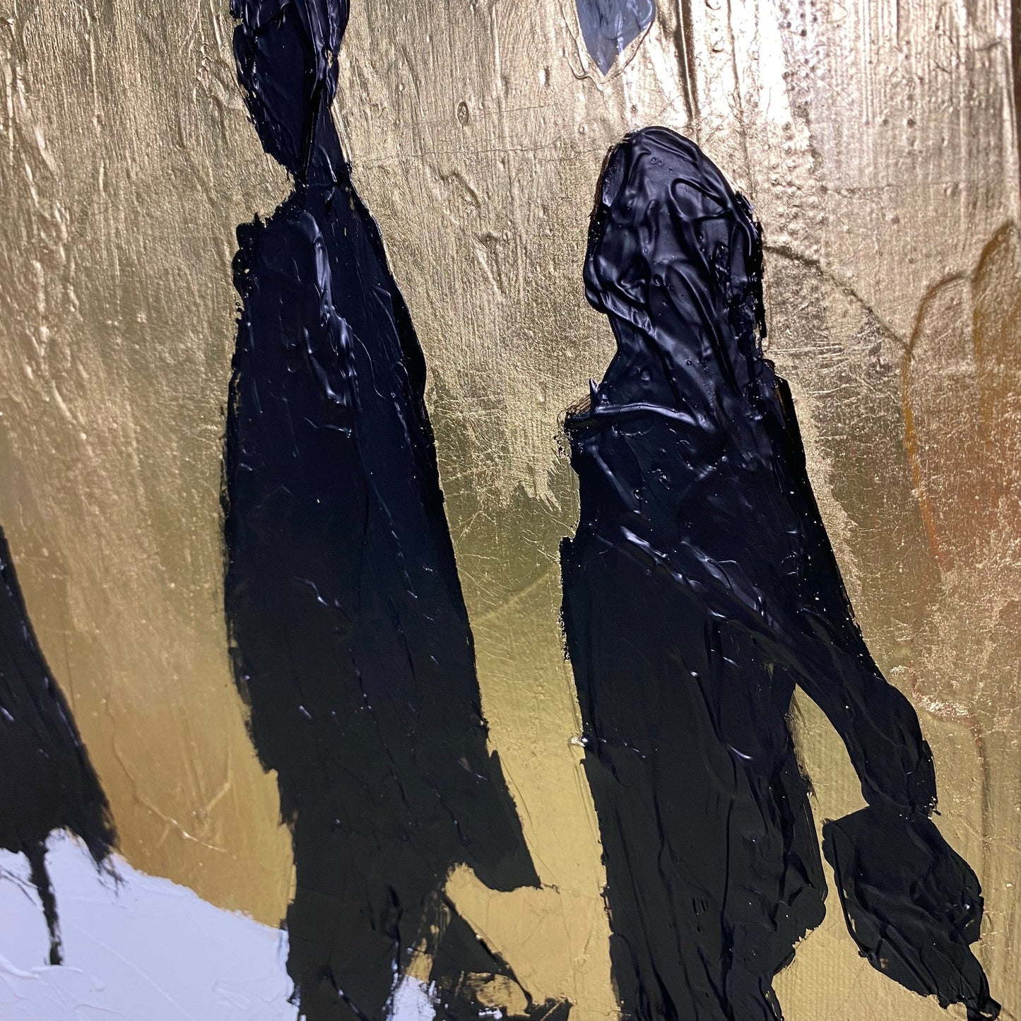 two dark silhouettes of people walking against a golden background.