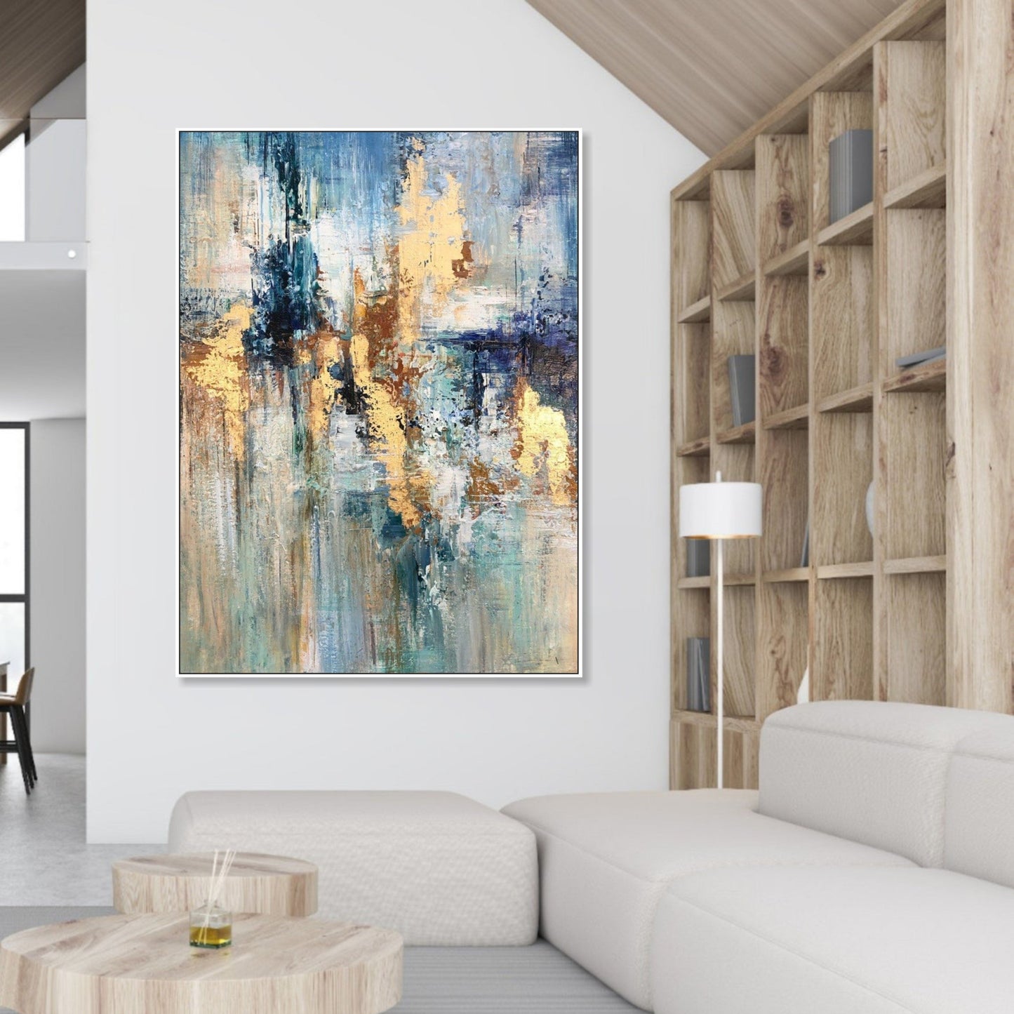 a modern living room with a large abstract painting hanging on the wall above a white sofa. The painting has a vibrant mix of blue, yellow, and green colors, creating a lively and dynamic atmosphere. The room also includes a wooden bookshelf and a wooden coffee table, contributing to the overall contemporary design.