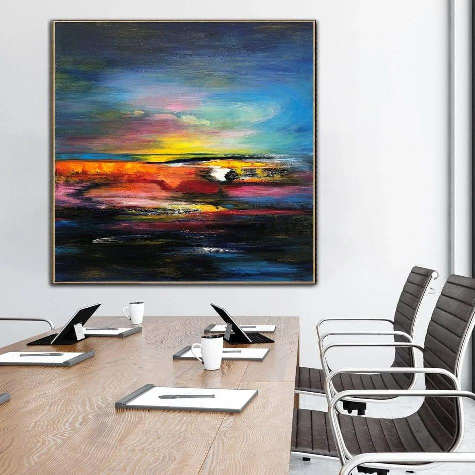 a large abstract painting hanging on a wall above a wooden table with chairs.