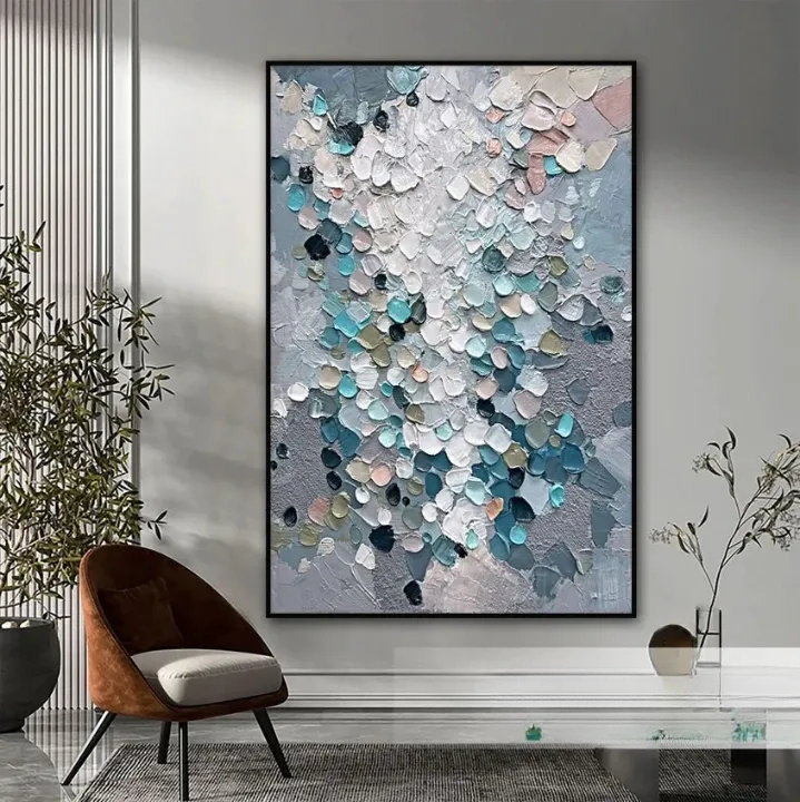 a large abstract painting hanging on a wall, with a brown chair and a glass table in the foreground.