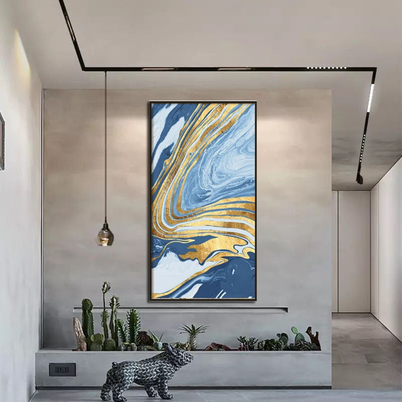 a painting hanging on a wall next to a plant